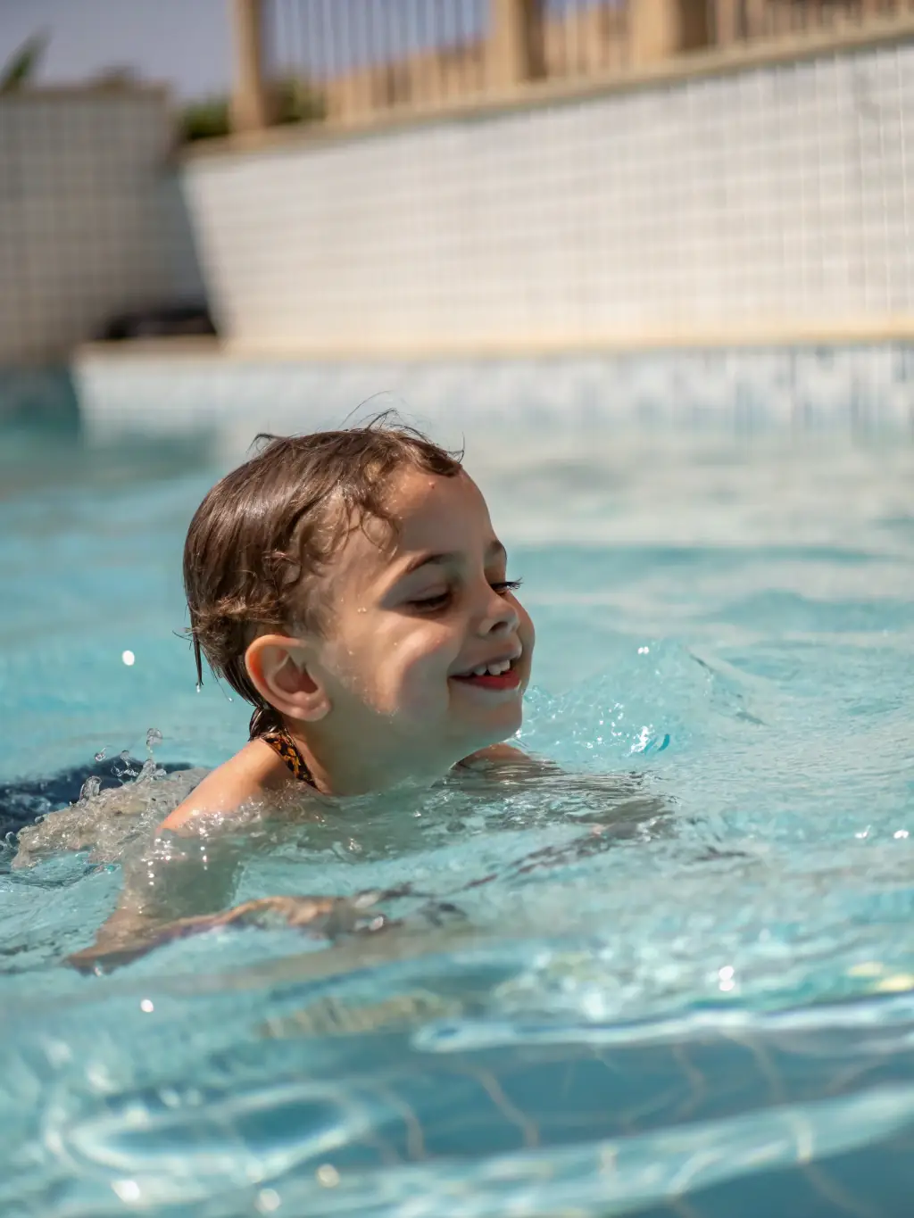 A student confidently swimming laps in a pool, representing personal achievement and skill development.